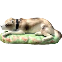Sculpture en porcelaine polychrome représentant un chien allongé sur un tapis d'herbe. Jacob Petit