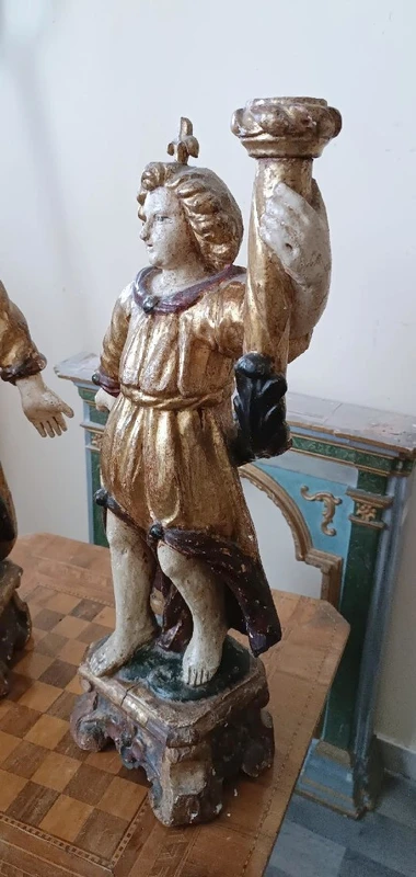 A pair of antique angel candlesticks, made of carved, lacquered, and gilded wood