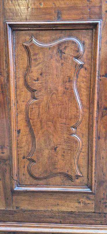 Antique 17th-century wardrobe from Parma, made of paneled and rusticated walnut