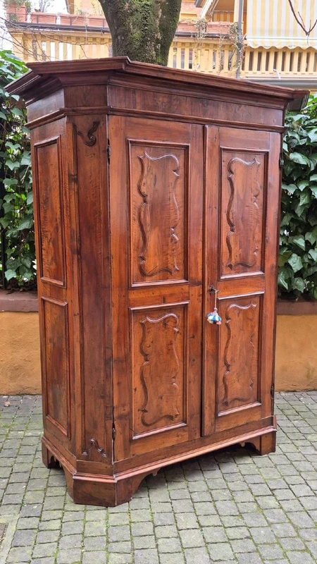 Antique 17th-century wardrobe from Parma, made of paneled and rusticated walnut