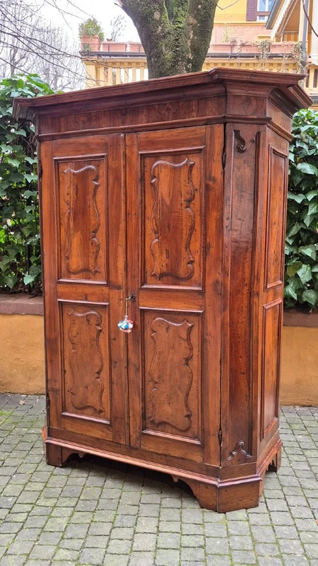 Antique 17th-century wardrobe from Parma, made of paneled and rusticated walnut