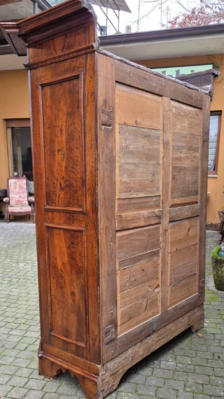 Antique 17th-century wardrobe from Parma, made of paneled and rusticated walnut