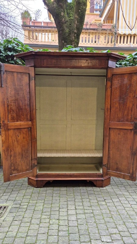 Antique 17th-century wardrobe from Parma, made of paneled and rusticated walnut