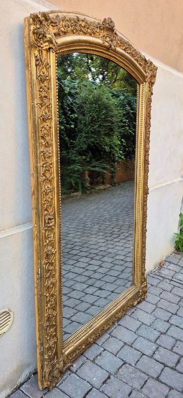 Antique gilded 19th-century mirror with an arched cornice