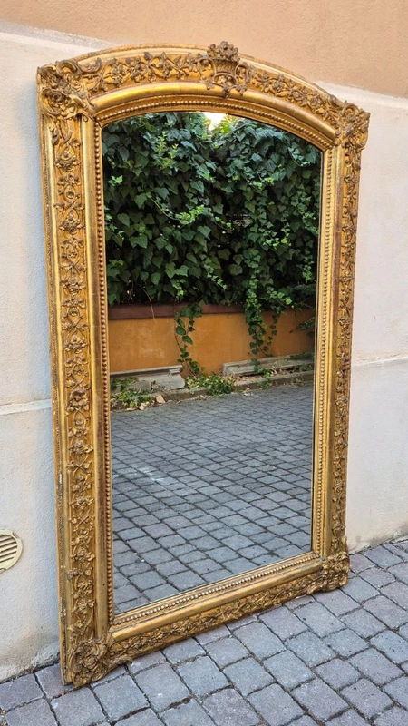 Antique gilded 19th-century mirror with an arched cornice
