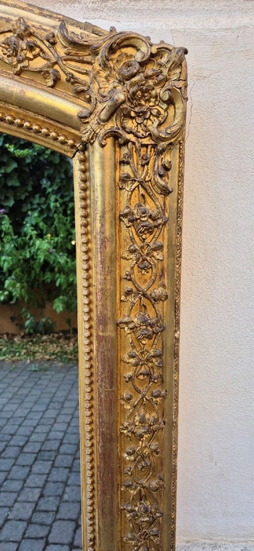 Antique gilded 19th-century mirror with an arched cornice