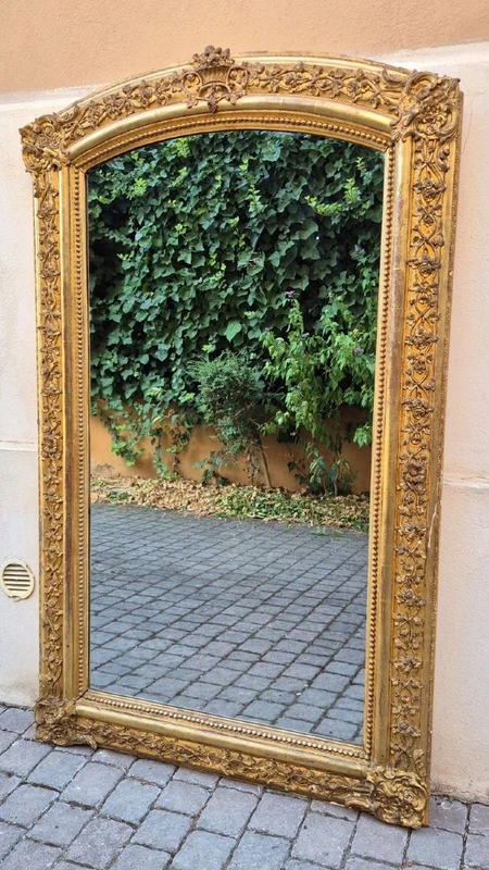 Antique gilded 19th-century mirror with an arched cornice