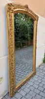 Antique gilded 19th-century mirror with an arched cornice