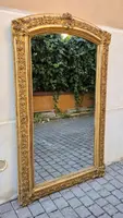 Antique gilded 19th-century mirror with an arched cornice