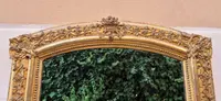 Antique gilded 19th-century mirror with an arched cornice