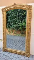 Antique gilded 19th-century mirror with an arched cornice