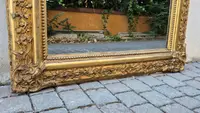 Antique gilded 19th-century mirror with an arched cornice