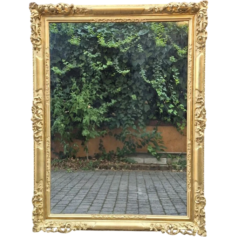 An antique Emilian mirror with openwork design, made of gilded wood, dating from the mid-19th century.