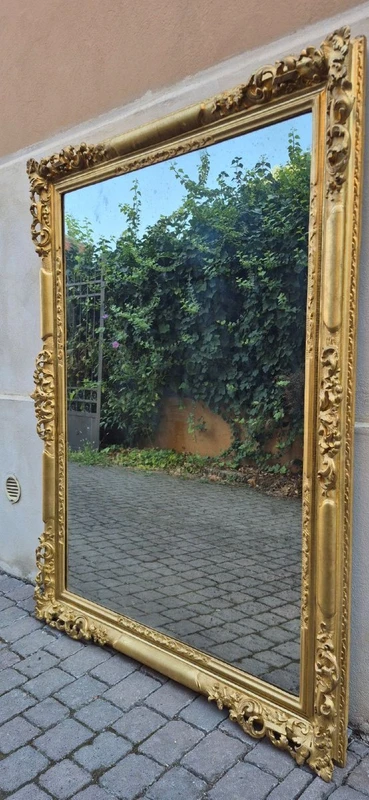 An antique Emilian mirror with openwork design, made of gilded wood, dating from the mid-19th century.
