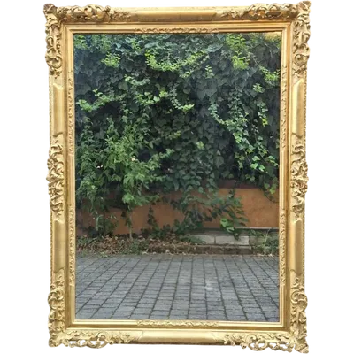 An antique Emilian mirror with openwork design, made of gilded wood, dating from the mid-19th century.