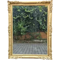 An antique Emilian mirror with openwork design, made of gilded wood, dating from the mid-19th century.