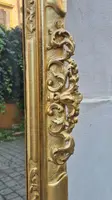 An antique Emilian mirror with openwork design, made of gilded wood, dating from the mid-19th century.