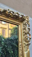 An antique Emilian mirror with openwork design, made of gilded wood, dating from the mid-19th century.