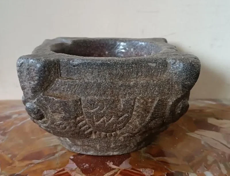 Antico mortaio in pietra scolpito